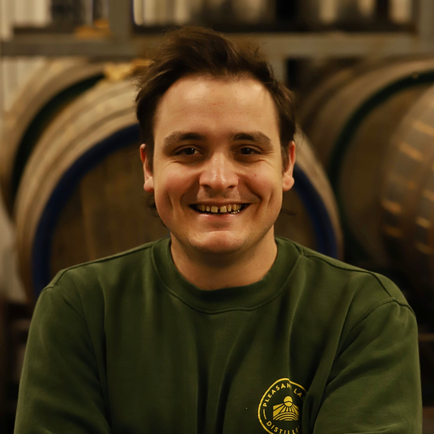 pleasant land distillery's head distiller joe hambleton wearing pleasant land logo